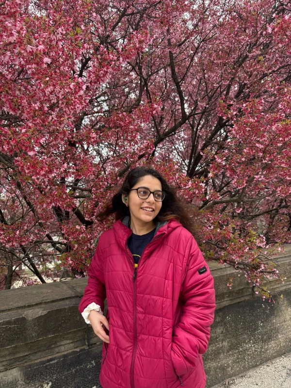 Suruchi smiling under cherry blossoms