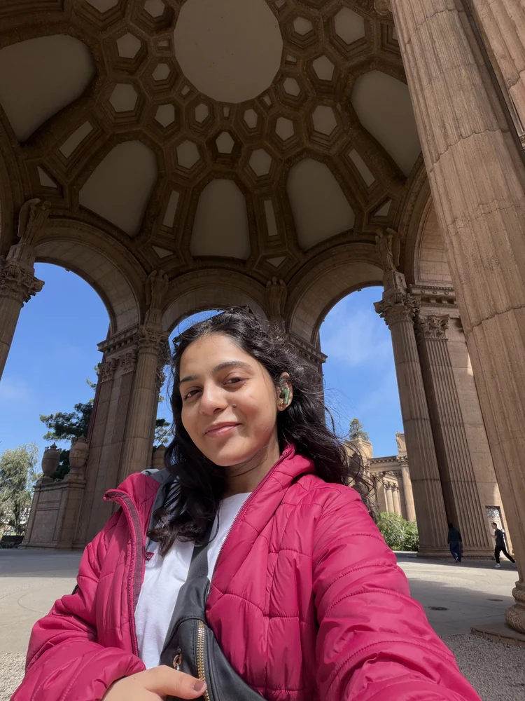 Suruchi Gokhale smiling under an archway at the Palace of Fine Arts